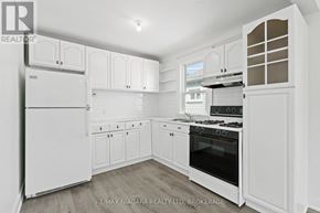 St. Catharines (E. Chester) apartment for rent - A white kitchen with a refrigerator, oven, and cabinets.