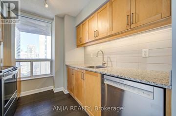 Toronto (Willowdale East) condo for rent - A kitchen with wooden cabinets and a stainless steel dishwasher.