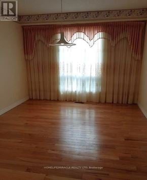 Oshawa (Pinecrest) apartment for rent - A room with wooden flooring and a window with curtains.