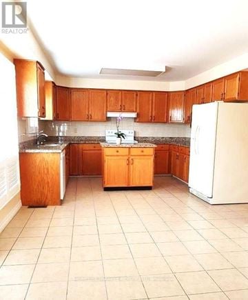 Oshawa (Pinecrest) apartment for rent - A kitchen with wooden cabinets and a white refrigerator.
