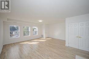 Orangeville multi-family for rent - A spacious room with wooden flooring and white walls.