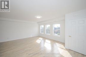 Orangeville multi-family for rent - A white room with wooden floors and a door on the right side.
