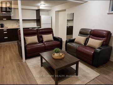 Vaughan (Glen Shields) apartment for rent - A living room with a brown leather couch and a wooden coffee table.