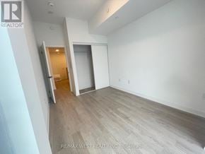 Hamilton (Riverdale) condo for rent - A spacious room with a doorway leading to another room.