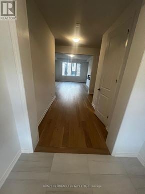 Barrie (Painswick South) apartment for rent - A long hallway with wooden floors and white walls.