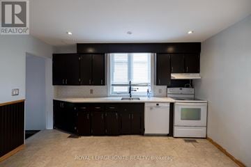 Toronto (Highland Creek) apartment for rent - A kitchen with black cabinets and white appliances.
