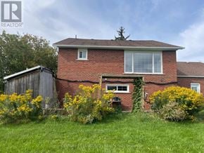 East Gwillimbury apartment for rent - A red brick house with a white window and a shed in the backyard.
