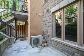 Toronto (Dovercourt-Wallace Emerson-Junction) townhouse for rent - A stone building with a balcony and a window.
