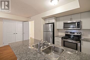 Toronto (Dovercourt-Wallace Emerson-Junction) townhouse for rent - A kitchen with a stainless steel refrigerator, microwave, and oven.