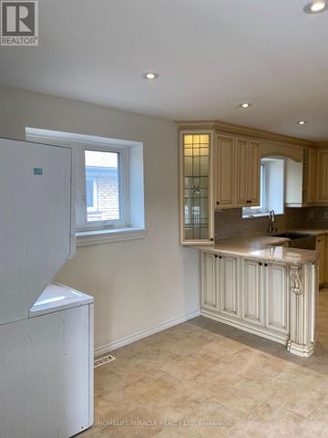 Mississauga (Malton) apartment for rent - A kitchen with a white fridge and wooden cabinets.