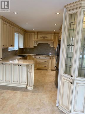 Mississauga (Malton) apartment for rent - A kitchen with a marble countertop and wooden cabinets.