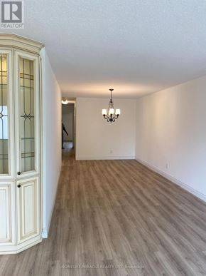 Mississauga (Malton) apartment for rent - A room with wooden flooring and a chandelier hanging from the ceiling.