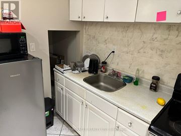 Mississauga (Mineola) apartment for rent - A kitchen with white cabinets and a black fridge.