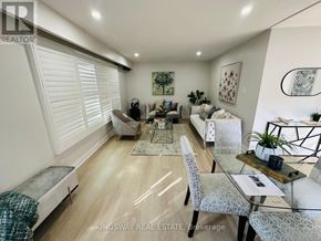 Kitchener apartment for rent - A well-lit, spacious living room with a dining area and a kitchen in the background.