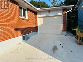 Kitchener apartment for rent - A red brick house with a white garage door.