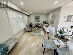 Kitchener apartment for rent - A well-lit, spacious living room with a dining area and a kitchen in the background.