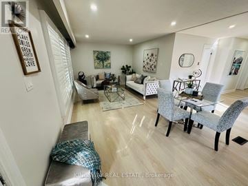 Kitchener apartment for rent - A well-lit living room with a grey sofa and a glass coffee table.