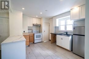 Oshawa (Central) apartment for rent - A kitchen with white appliances and wooden cabinets.