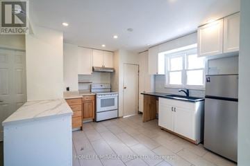 Oshawa (Central) apartment for rent - A kitchen with white appliances and wooden cabinets.