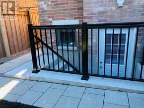 Whitby apartment for rent - A black metal fence in front of a brick wall.