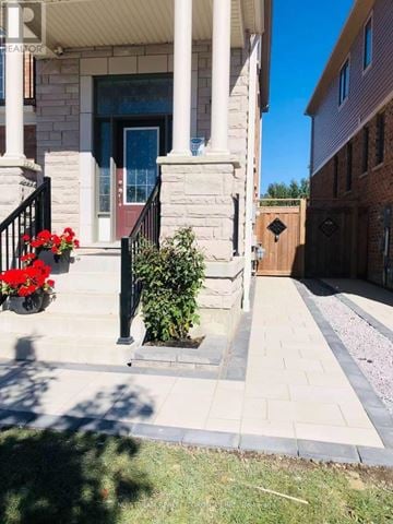Whitby apartment for rent - A house with a red door and a small garden in front.