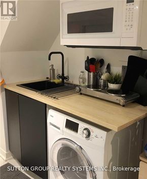 Toronto (Woodbine Corridor) apartment for rent - A kitchen with a washing machine and a microwave.