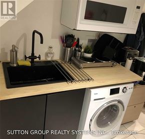 Toronto (Woodbine Corridor) apartment for rent - A kitchen counter with a washing machine underneath it.