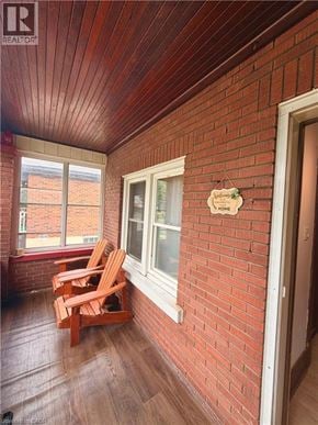 Brantford apartment for rent - A balcony with a wooden floor and a sign on the wall.