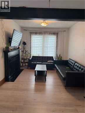 Brantford apartment for rent - A living room with a black leather couch and a wooden coffee table.