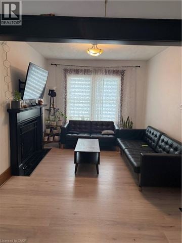 Brantford apartment for rent - A living room with a black leather couch and a wooden coffee table.