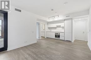 Toronto (Thorncliffe Park) condo for rent - A spacious kitchen with white cabinets and a wooden floor.