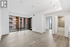 Toronto (Thorncliffe Park) condo for rent - A spacious room with wooden flooring and large windows overlooking a cityscape.
