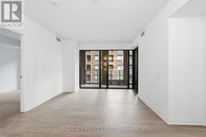 Toronto (Thorncliffe Park) condo for rent - A spacious room with a view of a building through the glass doors.