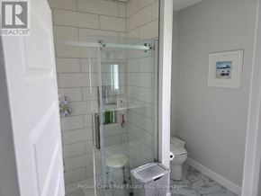 Goderich (Goderich (Town)) apartment for rent - A white bathroom with a glass shower door and a toilet.