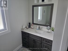 Goderich (Goderich (Town)) apartment for rent - A bathroom with a sink, mirror, and a window.