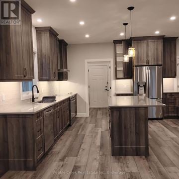 Goderich (Goderich (Town)) apartment for rent - A modern kitchen with dark wood cabinets and a white countertop.