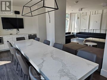 Toronto (York University Heights) condo for rent - A modern dining room with a long table and chairs.