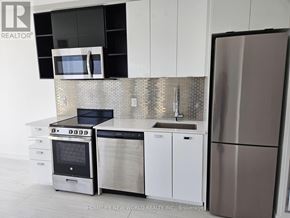Toronto (York University Heights) condo for rent - A modern kitchen with a stainless steel refrigerator, microwave, oven, and sink.