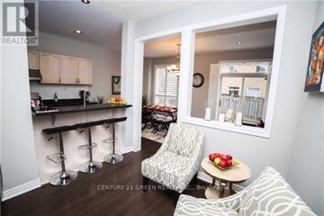 Mississauga (Churchill Meadows) apartment for rent - A living room with a bar area and a chair with a white and black pattern.