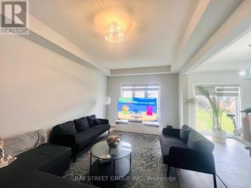 Niagara Falls (Brown) townhouse for rent - A living room with a large couch and a television.