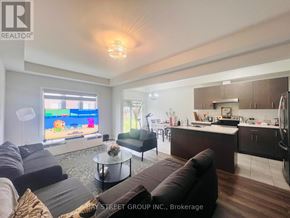 Niagara Falls (Brown) townhouse for rent - A living room with a couch, a coffee table, and a television.
