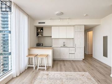 Vaughan (Vaughan Corporate Centre) condo for rent - A modern kitchen with white cabinets and a wooden island.