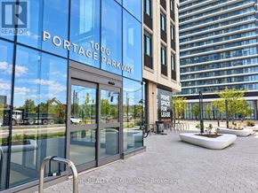 Vaughan (Vaughan Corporate Centre) condo for rent - The entrance to a building with a glass door and a sign that reads "Portage Parkway.".