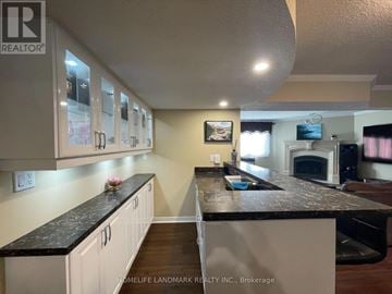 Georgina (Keswick North) apartment for rent - A kitchen with white cabinets and a black countertop.