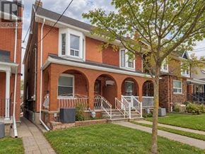 Toronto (Corso Italia-Davenport) apartment for rent - A red brick house with a tree in front.