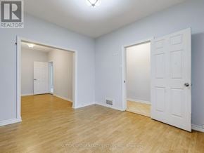 Toronto (Corso Italia-Davenport) apartment for rent - A room with white walls and wooden flooring, with two doors and a window.