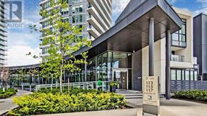 Toronto (Bayview Village) condo for rent - A modern building with a glass facade and a sign that reads "113 115".