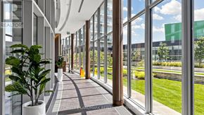 Toronto (Bayview Village) condo for rent - A hallway with a plant on the left and a sign that says "HOMELIFE AND MARK REALTOR".