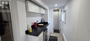 Oakville (Wo West) apartment for rent - A kitchen with a black counter top and white cabinets.