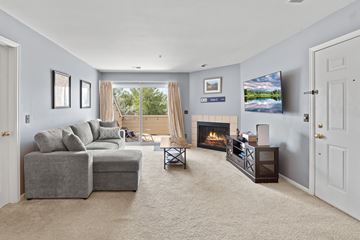 Boulder apartment for rent - A living room with a grey couch, a fireplace, and a television on the wall.